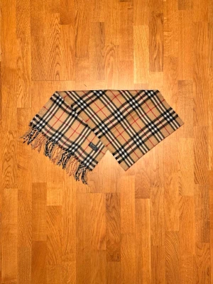 Beige Burberry halsduk - Säljer en beige halsduk från Burberry. Halsduken är i gott skick och är gjord i 100% kashmir. Var inte rädd för några frågor. Pris diskuteras inte!