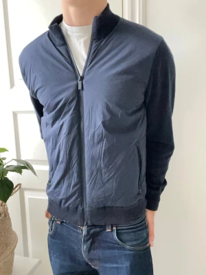John Henric cardigan  - John Henric cardigan i mörkblå färg. Extremt clean och väldigt slim fit. Modellen är 180 cm 75 kg och är optimal passform. Storlek S. Inga defekter som helst heller 🙏🎉