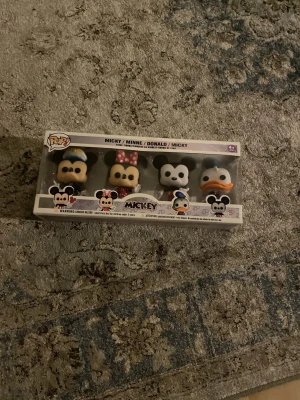 Funko Pop! Disney Mickey & Friends set - Säljer ett set med fyra Funko Pop! figurer från Disney: Mimmi, Musse, Kalle och Långben. Figurerna är små och kommer i originalförpackning med genomskinligt fönster. Perfekt för samlare eller som dekoration. Färgerna är svart, vit, rosa, blå och orange. Vet inte hur mycket de värda