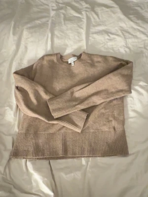 Beige stickad tröja & Other Stories - Mysig beige stickad tröja från & Other Stories Paris Atelier. Tröjan har rund halsringning, långa ärmar och bred ribbstickad kant nedtill. Själv aldrig använt men min moster tidigare haft den💕
