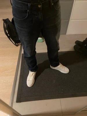 Mörkblå straight jeans från Lee - Säljer ett par mörkblå jeans från Lee med klassisk femficksdesign och raka ben. Jeansen har normal passform och är tillverkade i slitstarkt denimtyg av bomull. Perfekta för dig som gillar en enkel och tidlös look.   Size 30/32, condition very good used max 20 times. The tag in the back is a little bit broken, and i think it has always been i dont know. New price 110€/1200kr. 