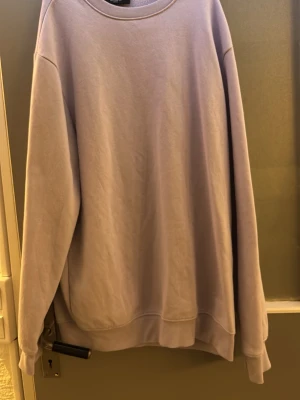 Ljuslila oversized sweatshirt - En stilren ljuslila sweatshirt från H&M i oversized modell. Tröjan har rund halsringning, långa ärmar och ribbade muddar vid ärmslut och nederkant. Perfekt för en avslappnad och trendig look. Tillverkad i mjukt bomullsmaterial.