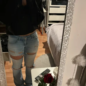Slitna lågmidjade jeans - Säljer dessa jeans från Nelly som jag gjorde några hål i, skit snygga men är för långa för mig. Jeansen har gått sönder där bak när jag skulle dra upp dom men går enkelt att sy ihop, och slitna där nere där av priset 