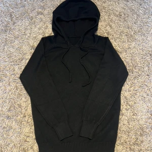 Merinoull svart hoodie med huva och snörning - Svart merinoull hoodie som är köpt fårn ett UF. Aldrig använd, storlek xs. 