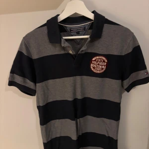 Randig pikétröja från Tommy Hilfiger - Pike från Tommy hilfiger md tryck på vänster bröst. Tröjan är i bra skick men är använd en del och är lite urtvättad. Tröjan är i storlek m men har en slim fit och passar även för s.