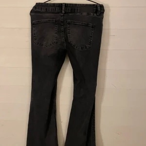 Svarta bootcut jeans från 157 - Snygga svarta jeans från 157 med bootcut-modell och klassisk femficksdesign. Jeansen har en mörk tvätt och är tillverkade i ett stretchigt denimtyg som sitter skönt. Perfekta för dig som gillar en retroinspirerad look med utsvängda ben.