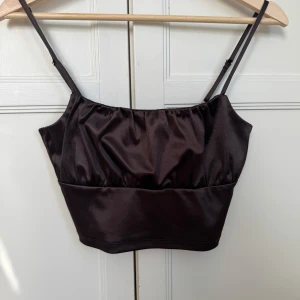 Brun siden topp - Brun siden topp från HM. Toppen är kort som en magtröja, justerbara band. :)