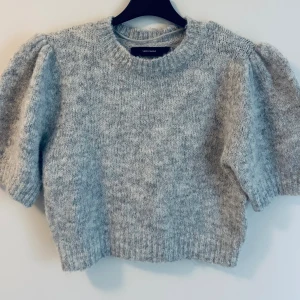 Grå kort stickad tröja från Vero Moda - Supermysig grå stickad tröja från Vero Moda med korta puffärmar, kort modell. 