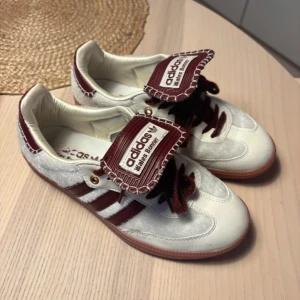 Adidas Wales Bonner sneakers vit/vinröd - Unika Adidas Wales Bonner sneakers i vitt och vinrött, modellen är en limited Edition collab men de är inte äkta adidas! Själv skulle jag inte säga att man märker något alls och de är bara använda en gång men säljs för min stortå fick inte plats😔😔