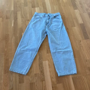 Carhartt Brandon Pant ljusblå jeans - Ljusblå jeans från Carhartt, modell Brandon Pant, med klassisk femficksdesign och broderad Carhartt-logga på bakfickan. Byxorna har en rak och loose passform med normal midja. Tillverkade i 100% bomull för en skön och slitstark känsla.