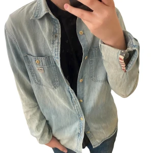 jeansskjorta från Ralph Lauren Denim & Supply - Snygg ljusblå jeansskjorta från Ralph lauren Denim & Supply med två bröstfickor och knappar. (Mycket liten på slitning på armen) 