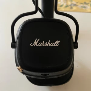 Marshall Major IV - Marshall Major IV trådlösa over-ear hörlurar i svart. Ikonisk design, bekväma öronkuddar och lång batteritid. USB-C och 3,5 mm anslutning. Mycket fint skick, inga synliga defekter eller slitage. Perfekt för musikälskare som vill ha både stil och ljudkvalitet. Alla sladdar medföljer. Köpte för 990 nypris, ägda i ungefär 12 månader. Priset kan diskuteras vid smidig affär
