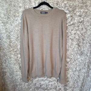 Beige bomullströja från Dressmann M - En stilren beige tröja från Dressmann i storlek M. Tillverkad i mjuk bomull med rund halsringning och långa ärmar. 