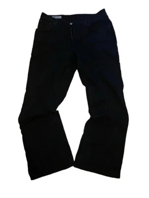 Svarta flared jeans från Zara - Säljer ett par svarta jeans från Zara med klassisk femficksmodell. Jeansen har normal passform och är tillverkade i ett slitstarkt bomullstyg. Perfekta för dig som gillar en enkel och clean look. jeansen passar storlek L / XL