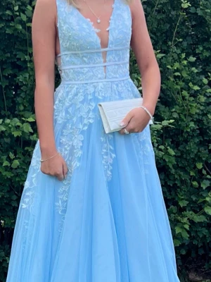 Ljusblå balklänning  - Magisk ljusblå långklänning med vackra broderade spetsdetaljer och blommigt mönster. Perfekt för bal eller student! Köpt för 3000kr använd 2 gånger!😊 pris kan diskuteras 