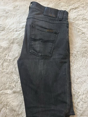  Nudie Jeans Co - Säljer ett par svarta jeans från Nudie jeans Co. Näst intill nya! Använda ett fåtal gånger! Storlek w=30/L=34! Hör av er vid frågor!
