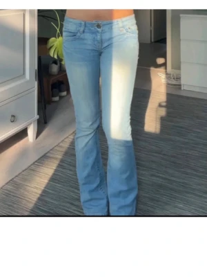 Ljusblå bootcut jeans - Säljer ett par ljusblå jeans med bootcut passform och låg midja. Jeansen har klassisk femficksdesign, knappgylf och är tillverkade i mjukt denimtyg. Perfekta för dig som gillar en avslappnad men ändå snygg stil. Har sytt ut dom lite mer i benen då jag tyckte dom satt lite skinny, nu är det en perfekt bootcut look!💖