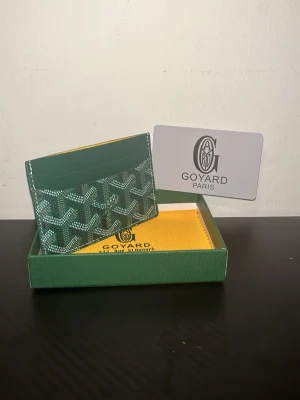 Gplånbok grön färg - En stilren grön plånbok med tidlös design som passar både vardag och fest. Tillverkad i slitstarkt material med en mjuk och exklusiv känsla. Den neutrala grå färgen ger ett modernt och elegant uttryck som enkelt matchar alla stilar.  Plånboken är praktiskt utformad med flera kortfack, sedelfack och ett säkert utrymme för mynt eller viktiga småsaker. Smidig storlek som passar perfekt i fickan utan att kännas klumpig.  Ett perfekt val för dig som vill kombinera funktion, kvalitet och stil.