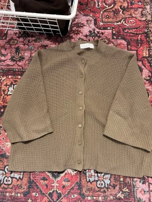 Beige stickad kortärmad kofta  - Säljer en kortärmad kofta köpt från Ullared, använd fåtal gånger 