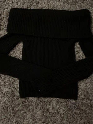 Svart offshoulder stickad tröja H&M - Säljer en svart stickad offshoulder tröja från H&M i storlek XS. Tröjan har bred ribbad kant upptill och långa ärmar. Perfekt för dig som vill ha en stilren och trendig look med en twist.🤍💕