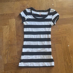 Snygg randig tröja - En tight, lång tröja perfekt för en 2000s inspirerad outfit! Har tyvärr en fläck på framsidan lite under kragen men man ser knappast den, fläcken syns inte på kamera. I bra skick förutom fläcken då. 