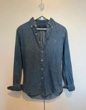 Ralph Laren jeansskjorta  - En i princip ny jeansskjorta från Ralph lauren i storlek S med en slim fit. Hör av er vid funderingar!