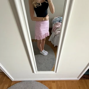 Rutig rosa kjol med volang från Gina Tricot - Kortkjol från Gina Tricot i rosa och vitt rutigt mönster. Kjolen har en volangkant längst ner.