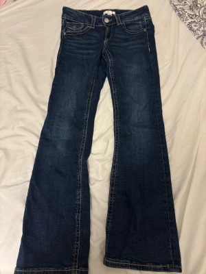 Mörkblå bootcut jeans från Gina Tricot - Snygga mörkblå jeans med bootcut passform. Storleken är 152 och midjemåtten rakt över är 33cm samt innerbenslängden är 70cm. Aldrig använts! 