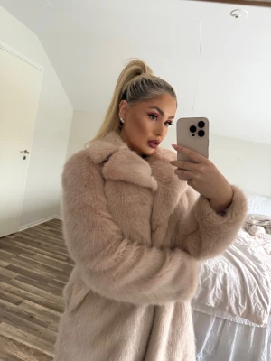 Ljusrosa pälsjacka med bred krage - Säljer en fluffig och lyxig ljusrosa pälsjacka med bred krage och långärmad design. Jackan har en oversized passform och är tillverkad i mjukt pälsmaterial som ger en riktigt glam vibe. Perfekt för dig som vill sticka ut och hålla dig varm under kalla dagar.