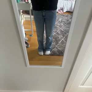 Ljusblå raka jeans från Levi's - Säljer ett par klassiska ljusblå Levi's jeans med rak passform och normal midja. Jeansen har fem fickor, dragkedja och knapp framtill. Perfekt vintagekänsla och passar till allt. Materialet är 100% bomull för en skön och tidlös look.