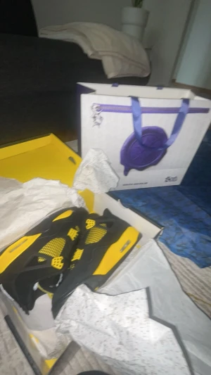 Nike Air Jordan 4 Retro 'Thunder' svart/gul - Säljer ett par Nike Air Jordan 4 Retro 'Thunder' sneakers i svart och gul. Skorna har klassisk mesh och skinn, med ikoniska Jumpman-loggor på plösen och hälen. De har snörning, platt sula och coola gula detaljer som verkligen sticker ut. Såklart är dem även ätka (southsoles emporia) köpte de för 6100. Box kommer med