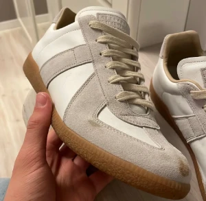 Maison Margiela GATs (äkthetsbevis) - Storlek 44!      Köpta i maj 2025 och har använt de runt 30 gånger sedan dess. Äkthetsbevis fås med vid köp✅. Det finns några fläckar men det går nog att få bort. Allt og följer med✅ Priset går att diskuteras✅. Svarar så snabbt jag kan!