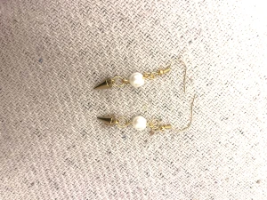 Guldiga örhängen med pärlor och koner - Snygga örhängen med guldfärgade krokar, vita pärlor och coola konformade detaljer i guld. Perfekt för dig som gillar att mixa klassiskt med edgy stil. Lätta att bära och ger en unik touch till din look.