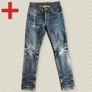 Nudie Jeans Grim Tim Dry  - Ett par helt sjuka Nudie Jeans Grim Tim dry i storlek 27/32. Svårt att hitta snyggare Grim Tims än detta! Otrolig Patina från år av användning. Fint skick men finns några mindre slitningar. Skriv om du har frågor!  Mått: Midja – 36 cm, Lår – 23 cm, Innersöm – 76 cm, Yttersöm – 99 cm, Benöppning – 15 cm