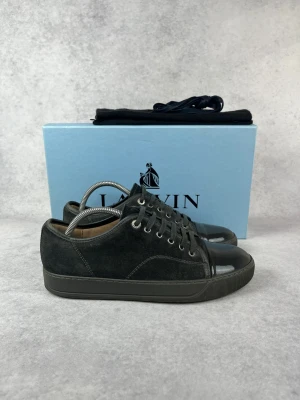 Lanvin DBB1 cap toe sneaker - – Condition: 8,5/10  - Size: 40/UK6  – What is included: Box & dustbag  – Retail price: 5000 + SEK  Please note that Lanvins fit big and our recommendation is to go one size down