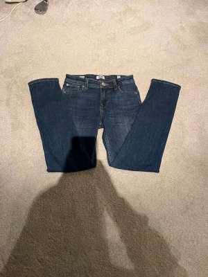 Mörkblå slim jeans Jack & Jones i stl 146 - Snygga mörkblå slim fit jeans från Jack & Jones, modell Glenn. Klassisk femficksdesign, normal midja och smal passform. Jeansen är tillverkade i mjukt denimtyg med lite stretch för extra komfort. Perfekta för dig som gillar en stilren look. Nästan oanvända 