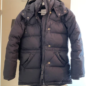 Mörkblå dunjacka från Boomerang XXS - Säljer en mörkblå dunjacka från Boomerang i storlek XXS. Modellen är Alexandra down. Har endast använts vid kalla dagar och är väldigt skön att bära. Säljer eftersom den är för liten för mig nu