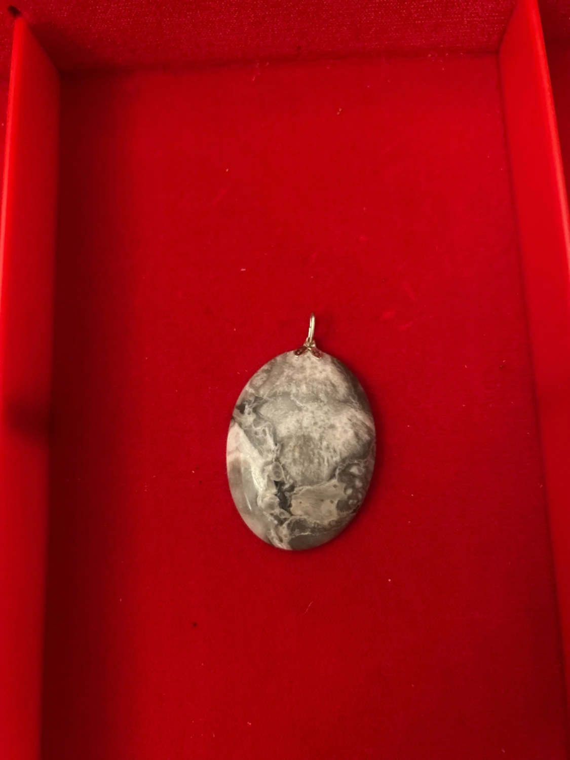 Gråmarmorerad oval halsbandshänge