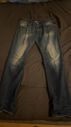 Blå jeans från Diesel Industry - Säljer ett par blå jeans från Diesel Industry med snyggt slitna detaljer och klassisk femficksdesign. Jeansen har raka ben och normal passform, tillverkade i robust denim. Storlek är W31/L32. Köpta i butik för 1 år sen ungefär. Pris kan diskuteras vid snabbaffär, hör gärna av er vid frågor eller funderingar😁