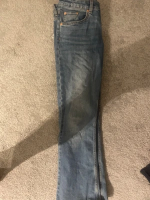 Blå bootcut jeans från 157, S kort - Snygga blå jeans från 157 i bootcut-modell med låg midja. Klassisk femficksdesign och kontrastsömmar. Jeansen är tillverkade i jeansmaterial och har en kortare benlängd, perfekt för dig som vill ha en chill och avslappnad look.