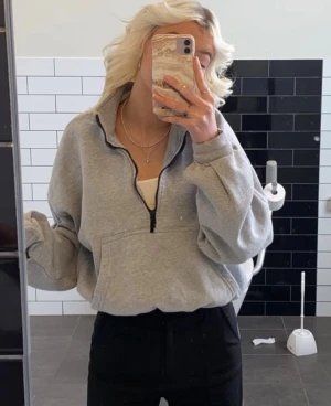 Grå half zip hoodie  - Säljer en grå hoodie från Boohoo med half zip och stor magficka. Tröjan har långärmade, loose fit ärmar och elastisk nederkant. Mysig inuti perfekt för vinter och höst! Storlek XL MEN skulle egentligen säga att den passar XS/S/M🩶