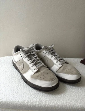 ”Ironstone” Nike Dunk Low - Säljer ett par beige/vita Nike Dunk Low som kallas ”Ironstone”. Knappt använda, inte riktigt min stil helt enkelt