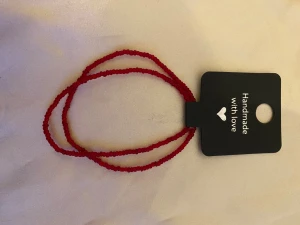 Handgjort rött pärlarmband - Snyggt handgjort armband med små röda pärlor. Armbandet är tunt och består av två slingor som ger en cool och enkel look. Perfekt för dig som gillar färg och vill ha något unikt på handleden.