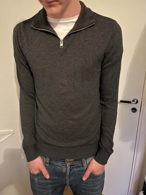 Mörkgrå half zip-tröja Jack & Jones - Mörkgrå långärmad tröja från Jack & Jones med half zip-dragkedja. Perfekt för lager-på-lager och enkel att matcha med jeans. Storlek S, skriv vid frågor!!