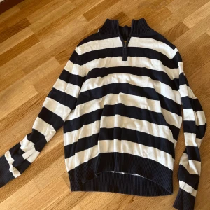 Randig stickad tröja från Dressmann - Tjock tröja med zip, svart vita ränder. Finns två märken som inte försvinner från tröjan men märks inte så mycket!