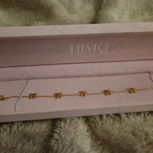 Guldigt armband med fjärilar från HIMO - Supersött armband i guld från HIMO med små fjärilar längs hela kedjan. Kommer i en lyxig rosa ask och är perfekt för dig som vill ha något gulligt och unikt på handleden. Kedjan är tunn och fjärilarna ger en lekfull vibe. OBS lådan ingår inte