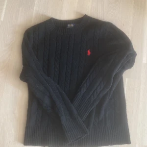 Svart stickad tröja från Polo Ralph Lauren - Svart kabelstickad Ralph lauren tröja i fint skick. Storleken är Xs och passar dig som är 160-170