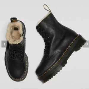 Svarta Dr. Martens Jadon FL boots - Säljer ett par svarta Dr. Martens Jadon FL boots med grov platt sula, snörning och dragkedja på sidan. Insidan är fodrad med mjuk beige päls för extra värme. Klassisk gul söm runt sulan och robust skinnmaterial. Perfekta för kalla dagar.