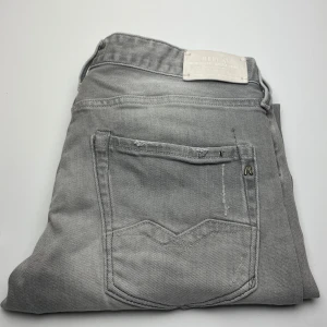 Grå Replay Waitom jeans - Snygga grå jeans från Replay i modellen Waitom. Klassisk femficksdesign med diskreta detaljer och logga på bakfickan. Jeansen har en rak passform och är tillverkade i mjukt bomullsmaterial. Perfekta för en avslappnad och stilren look.