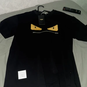 Svart Fendi t-shirt med dragkedja - Köpte den för 3 dagar sen har ba använt den en gång och de va när ja testa den o såg att den va stor i storleken står s fast den är som M nästan L helt ny skick priset kan diskuteras gärna fråga om mer bilder 